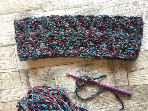 The ear warmer is made in shell stitch along the width of the piece